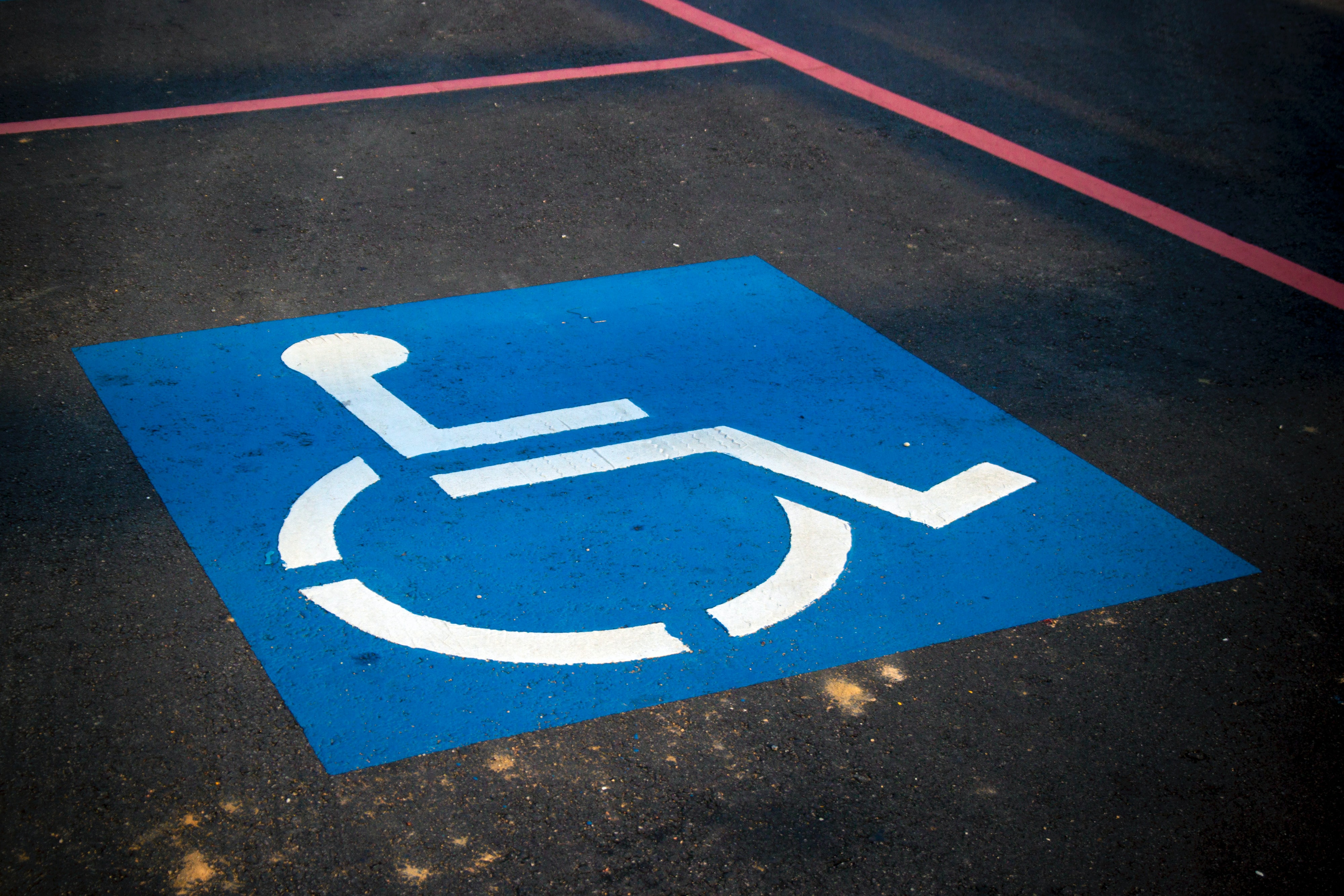 A parking spot with the international sign for accessible parking spraypainted on it