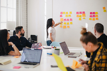 Femme plaçant des notes autocollantes sur un mur