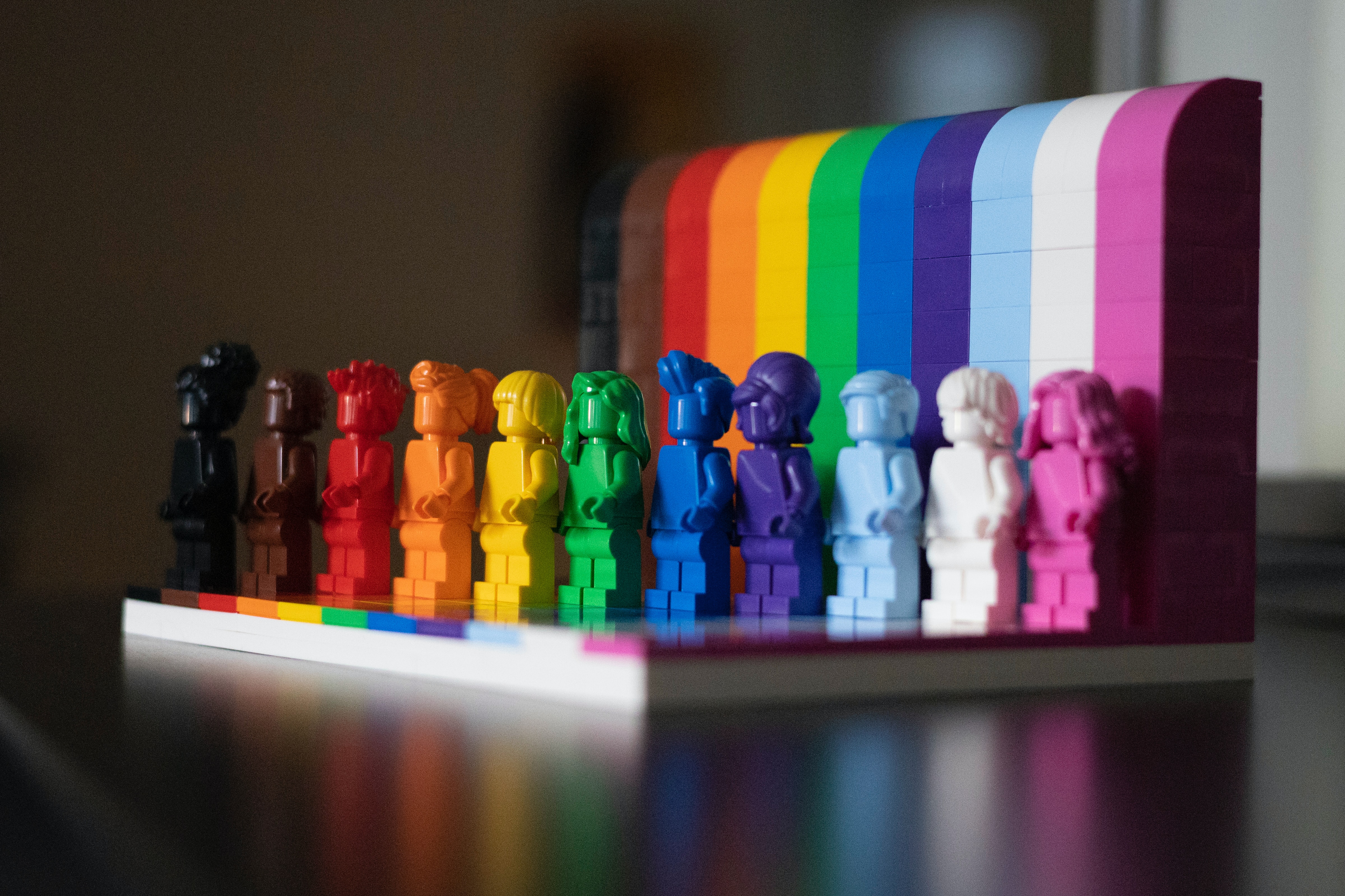 Lego minifigs lined up in the colours of the Pride flag