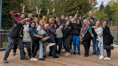 Une photo de groupe de tou·tes les participant·es souriant à l’appareil photo.