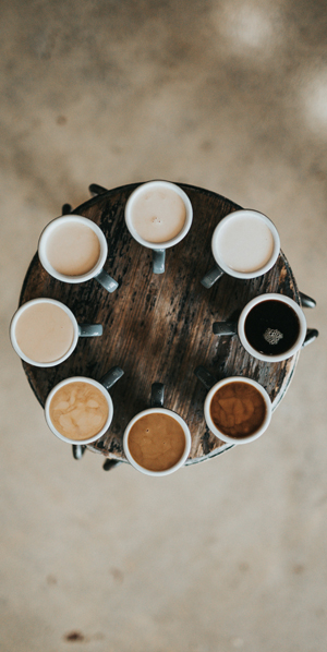 Huit tasses de caf&eacute; dispos&eacute;es en cercle, vues d&rsquo;en haut. Les caf&eacute;s ont tous un degr&eacute; d&rsquo;intensit&eacute; diff&eacute;rent et sont class&eacute;s du plus fort au plus l&eacute;ger tout autour du cercle.