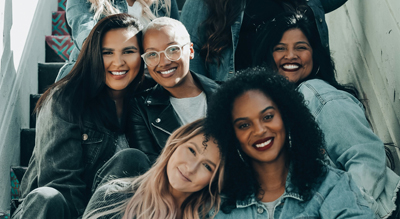 Des femmes de différentes origines culturelles, assises sur un escalier dans une atmosphère chaleureuse.