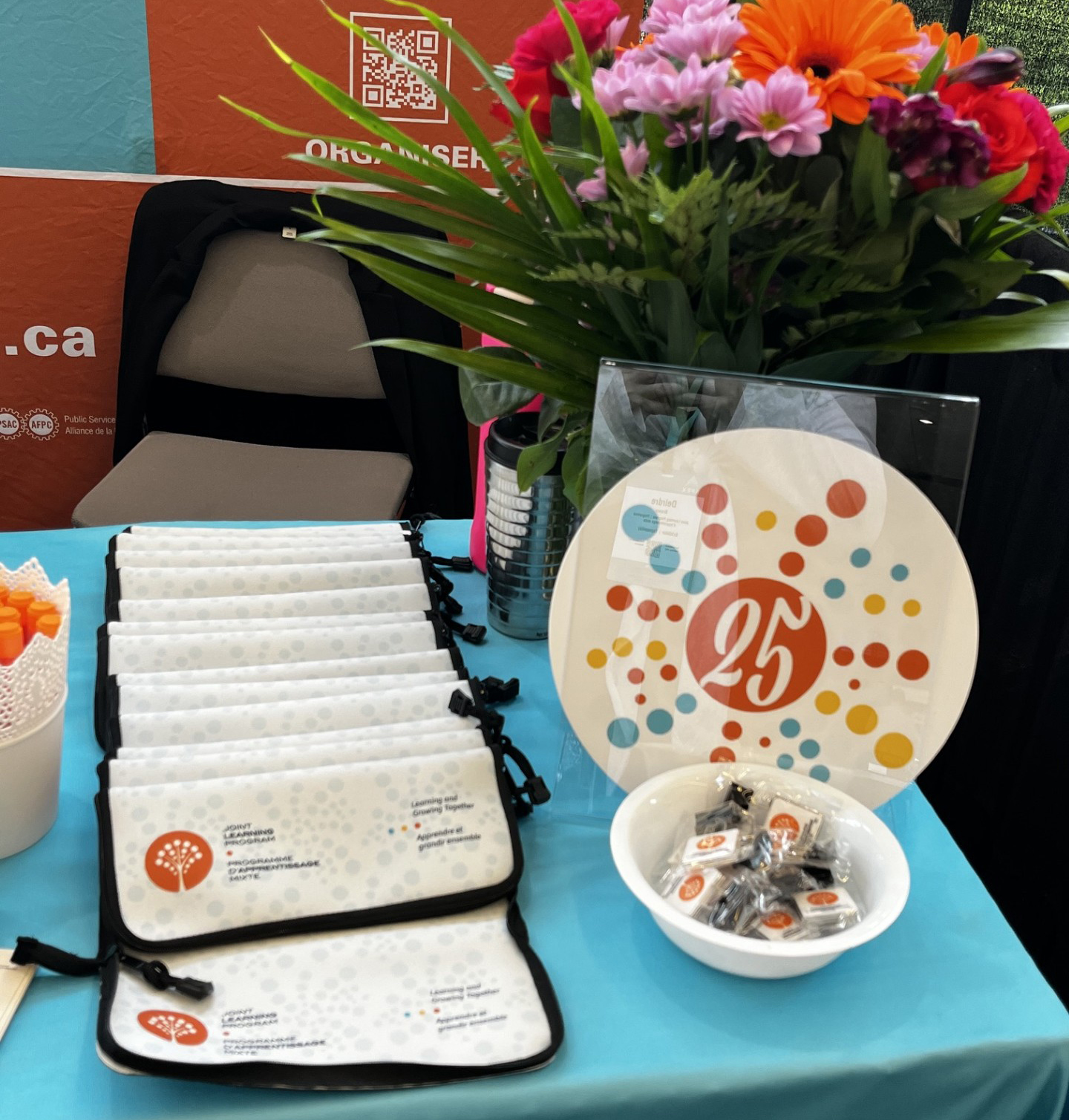 The booth table, featuring 25th anniversary branding 